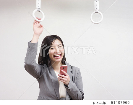 つり革につかまる笑顔のビジネスウーマン 61407966