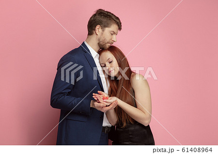 Valentine's day celebration, happy caucasian couple isolated on coral background Valentine's day celebration, happy caucasian couple isolated on coral background 61408964