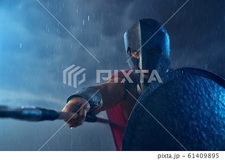 Muscular spartan fighting with spear. 61409895