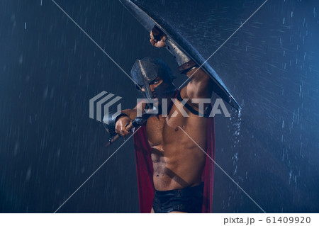 Spartan fighting with spear in rain. Spartan fighting with spear in rain. 61409920