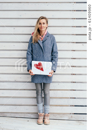 woman outside with gift box with a heart 61409960