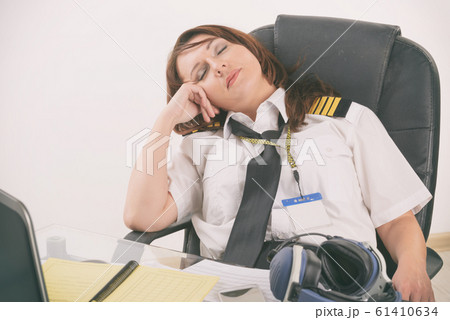 Woman airline pilot sleeping in the office 61410634