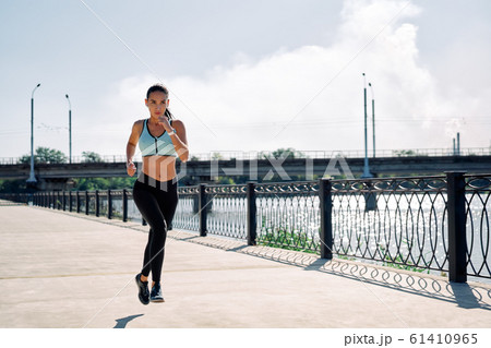 Young fitness woman runner running at riverside Young fitness woman runner running at riverside 61410965