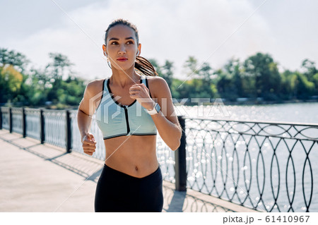 Young fitness woman runner running at riverside Young fitness woman runner running at riverside 61410967