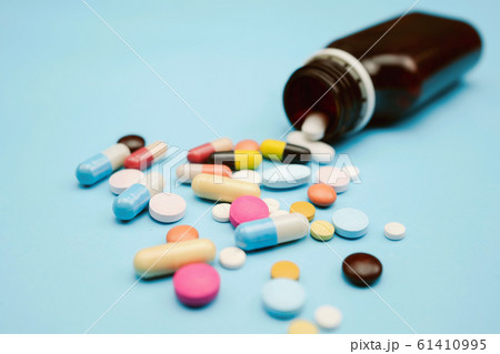 Pour the medicine out bottle on blue background Pour the medicine out bottle on blue background 61410995