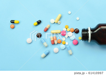 Pour the medicine out bottle on blue background Pour the medicine out bottle on blue background 61410997