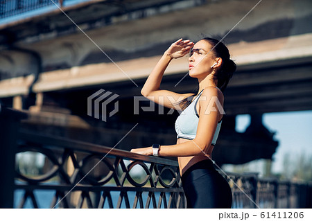 Sporty woman relax and looking away during outdoors exercising Sporty woman relax and looking away during outdoors exercising 61411206