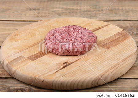 Raw pink beef cutlet on a cutting board.. Raw pink beef cutlet on a cutting board.. 61416362