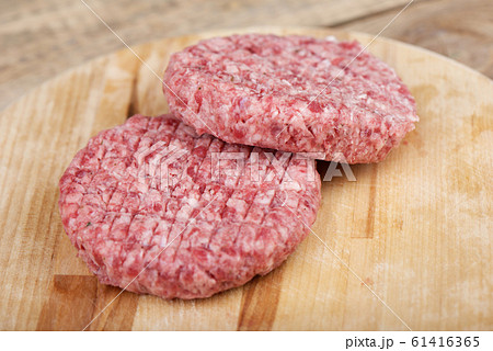 Soft focus. Two raw pink beef cutlets on a cutting board. Soft focus. Two raw pink beef cutlets on a cutting board. 61416365