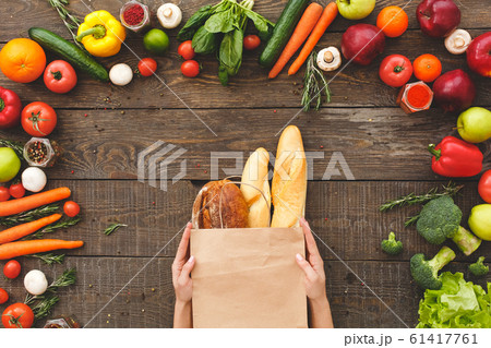 Woman hands with bread near raw organic vegetables on table Woman hands with bread near raw organic vegetables on table 61417761