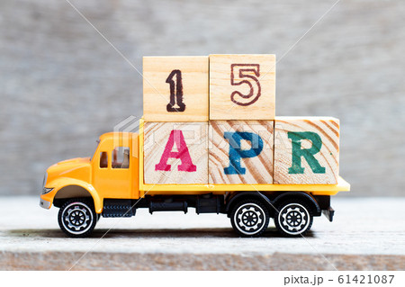 Truck hold letter block in word 15apr on wood background Truck hold letter block in word 15apr on wood background 61421087