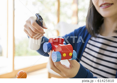 子供のおもちゃをアルコール除菌する母親手元 61425810