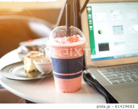 Businesswomen drinking strawberry smoothie fresh and cake sweet dessert health food lifestyle between work freelance.Laptop Notebook computer technology digital is on table wood sofa black color Businesswomen drinking strawberry smoothie fresh and cake sweet dessert health food lifestyle between work freelance.Laptop Notebook computer technology digital is on table wood sofa black color 61429683