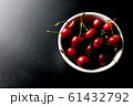 Cherry covered with steam in a bowl on dark ground. 61432792