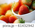Fresh strawberries in a white cup, Put on the white fabric backing pad, On the white table. 61432942