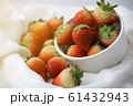 Fresh strawberries in a white cup, Put on the white fabric backing pad, On the white table. 61432943