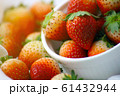Fresh strawberries in a white cup, Put on the white fabric backing pad, On the white table. 61432944