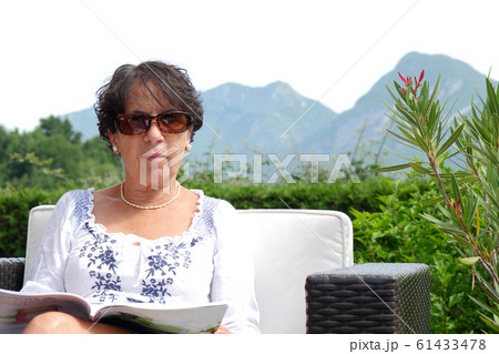 Portrait of  smiling middle age woman sitting in 61433478