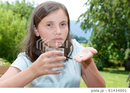 cute girl child taking pill with glass of water cute girl child taking pill with glass of water 61434001