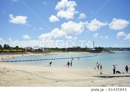沖縄の北谷町のアメリカンビレッジにあるサンセットビーチの浜辺のビーチパラソル 浮き輪とヤシの木 の写真素材