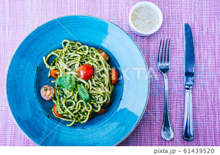 Pici pasta with green pesto sauce and cherry Pici pasta with green pesto sauce and cherry 61439520