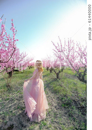 Woman in natural nature on the background of flowering peach trees 61440000