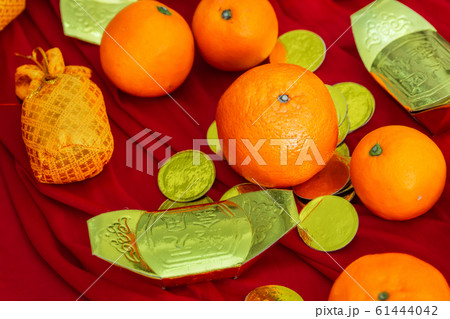 Oranges and gold on red fabric , Chinese New Year 61444042