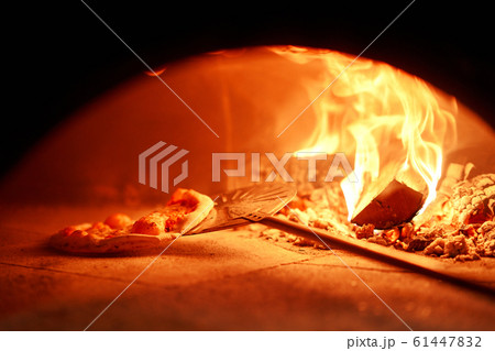 Baked tasty margherita pizza in Traditional wood oven in Naples restaurant, Italy. Original neapolitan pizza. Red hot coal. Baked tasty margherita pizza in Traditional wood oven in Naples restaurant, Italy. Original neapolitan pizza. Red hot coal. 61447832