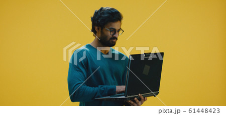 Young man typing on laptop 61448423