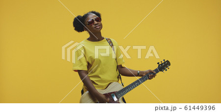 Young woman playing electric guitar Young woman playing electric guitar 61449396