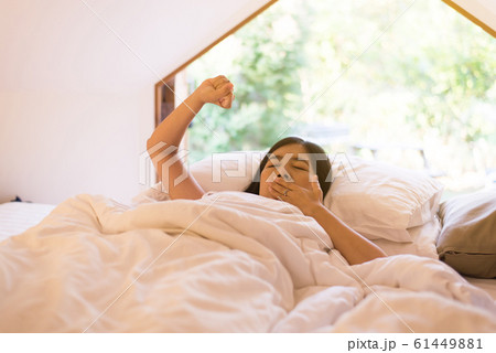 Beautiful asian woman stretching in tent after wake up in the morning,Happy and smiling,Relaxing time Beautiful asian woman stretching in tent after wake up in the morning,Happy and smiling,Relaxing time 61449881
