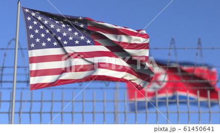 Waving flags of the USA and North Korea separated by barbed wire fence. Conflict related conceptual 3D rendering 61450641