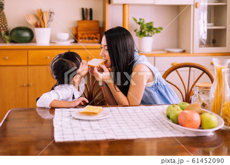 Mother and little daughter having fun with breakfast together at home kitchen in the morning,Healthy food concept 61452090