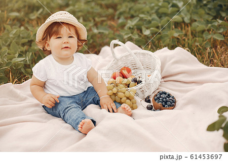 Cute little sitting on a blanket in a park 61453697
