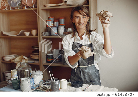A young woman makes dishes in a pottery 61453707