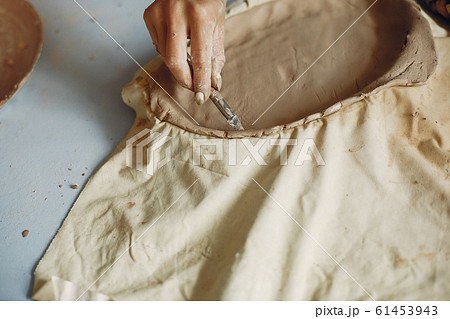 A young woman makes dishes in a pottery 61453943