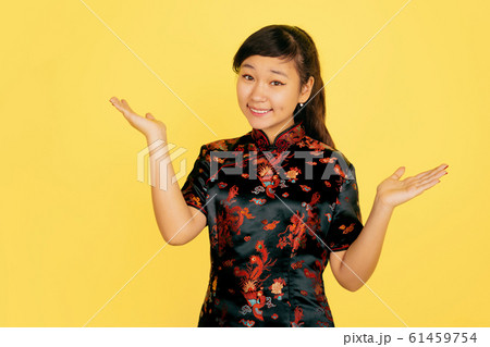 Happy Chinese New Year. Asian young girls's portrait isolated on yellow background 61459754