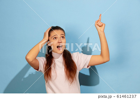 Caucasian teen girl portrait isolated on blue studio background Caucasian teen girl portrait isolated on blue studio background 61461237