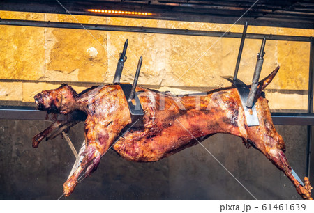 The carcass of a lamb is roasted on a spit. 61461639