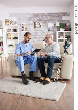 Young male doctor in nursing home taking notes on tablet pc Young male doctor in nursing home taking notes on tablet pc 61461946