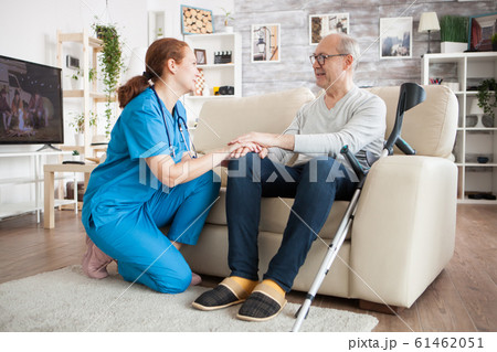 Old man with glasses sitting on couch in nursing room 61462051