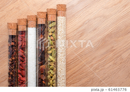 Various spices in glass flasks on a wooden kitchen 61463776