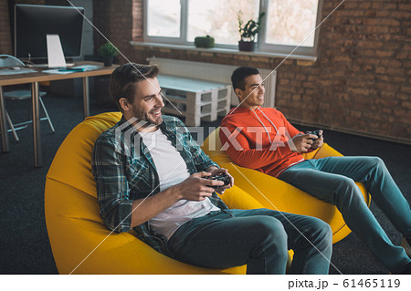 Happy relaxed man sitting in the beanbag chairs 61465119