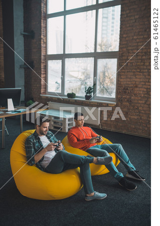 Pleasant happy men playing video games together 61465122