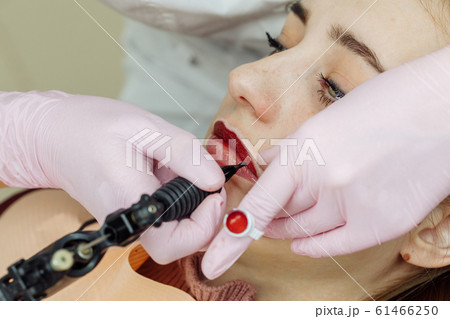 Woman having permanent makeup on lips Woman having permanent makeup on lips 61466250