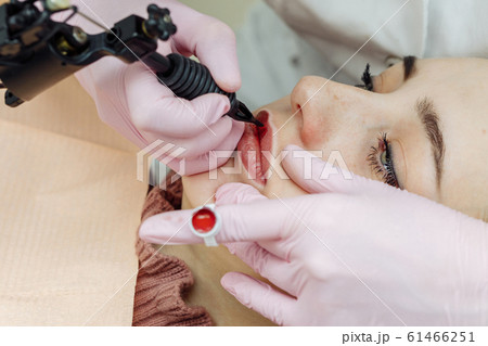 Woman having permanent makeup on lips Woman having permanent makeup on lips 61466251