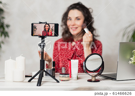Influencer Young girl blogger talks about makeup. Woman recording video blog tells how to be beautiful. Bloger talks facial beauty treatments. Vloggre broadcasts how to use of cosmetic 61466626