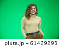 Glowing girl posing on green background, looking positive, smiling. 61469293