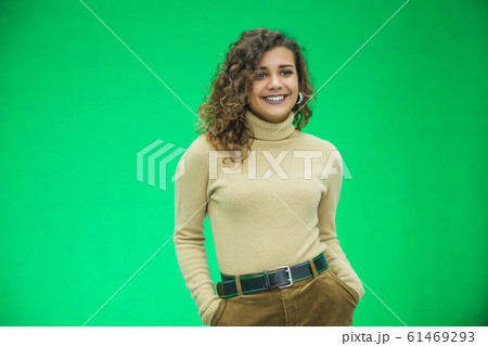Glowing girl posing on green background, looking positive, smiling. 61469293