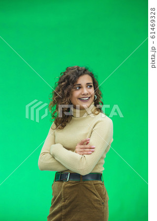 Portrait of gorgeous female model posing in white fashion clothes in studio over green background. Portrait of gorgeous female model posing in white fashion clothes in studio over green background. 61469328